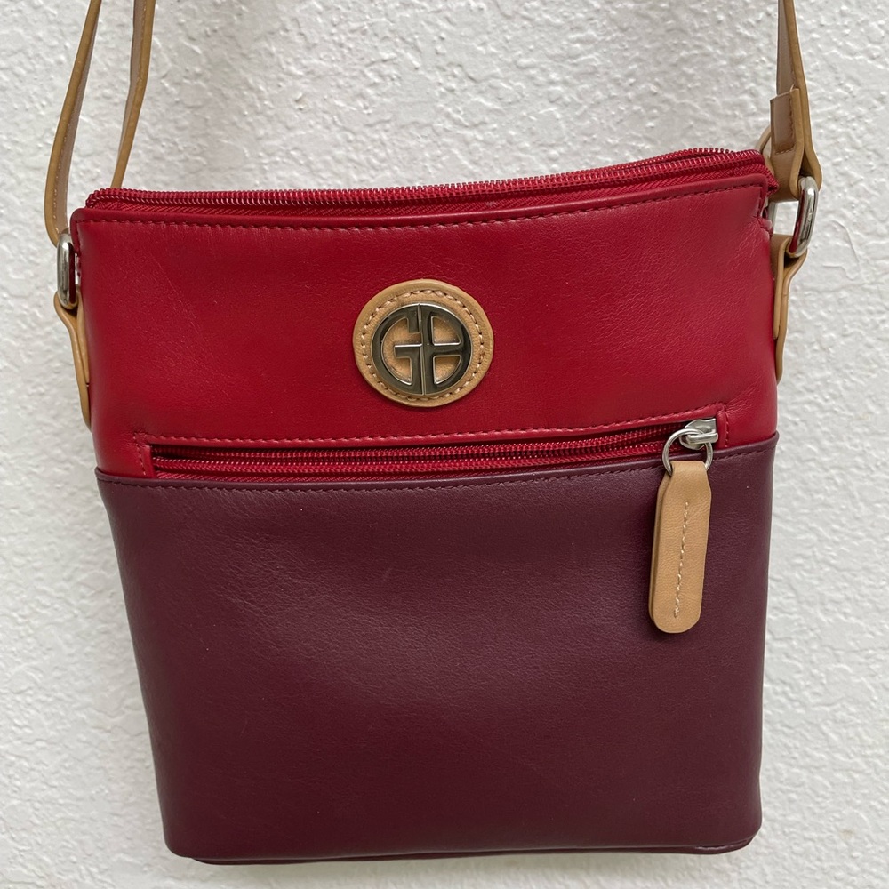 Crossbody -leather with man-made trim.  Adjustable shoulder strap
